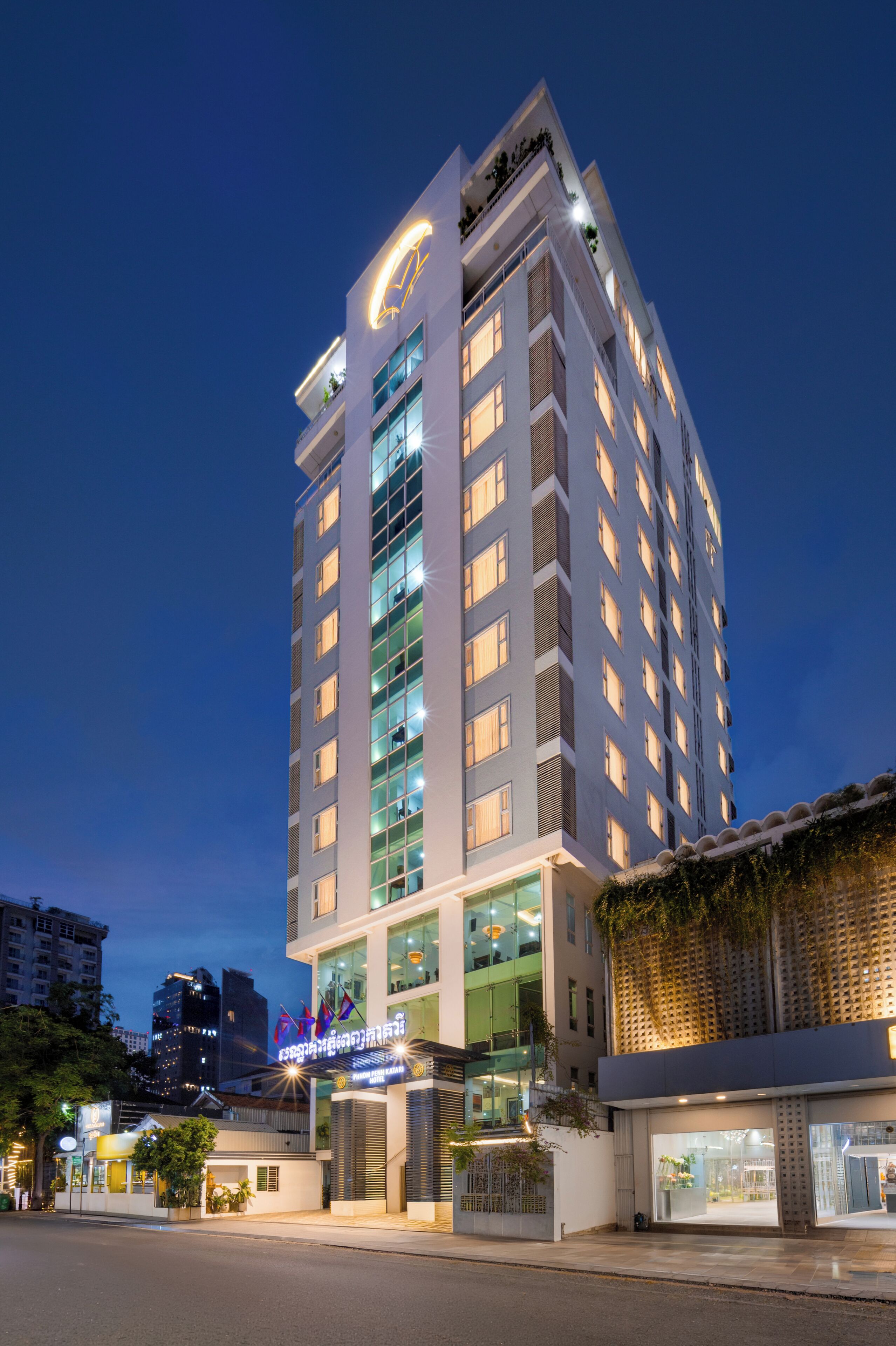 Un hotel moderno con un letrero llamativo, varios pisos y una fachada bien iluminada.