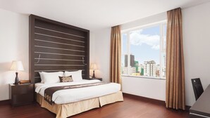 A modern hotel room with a large bed, a city view, and a dark headboard. - Phnom Penh Katari Hotel (Phnom Penh)