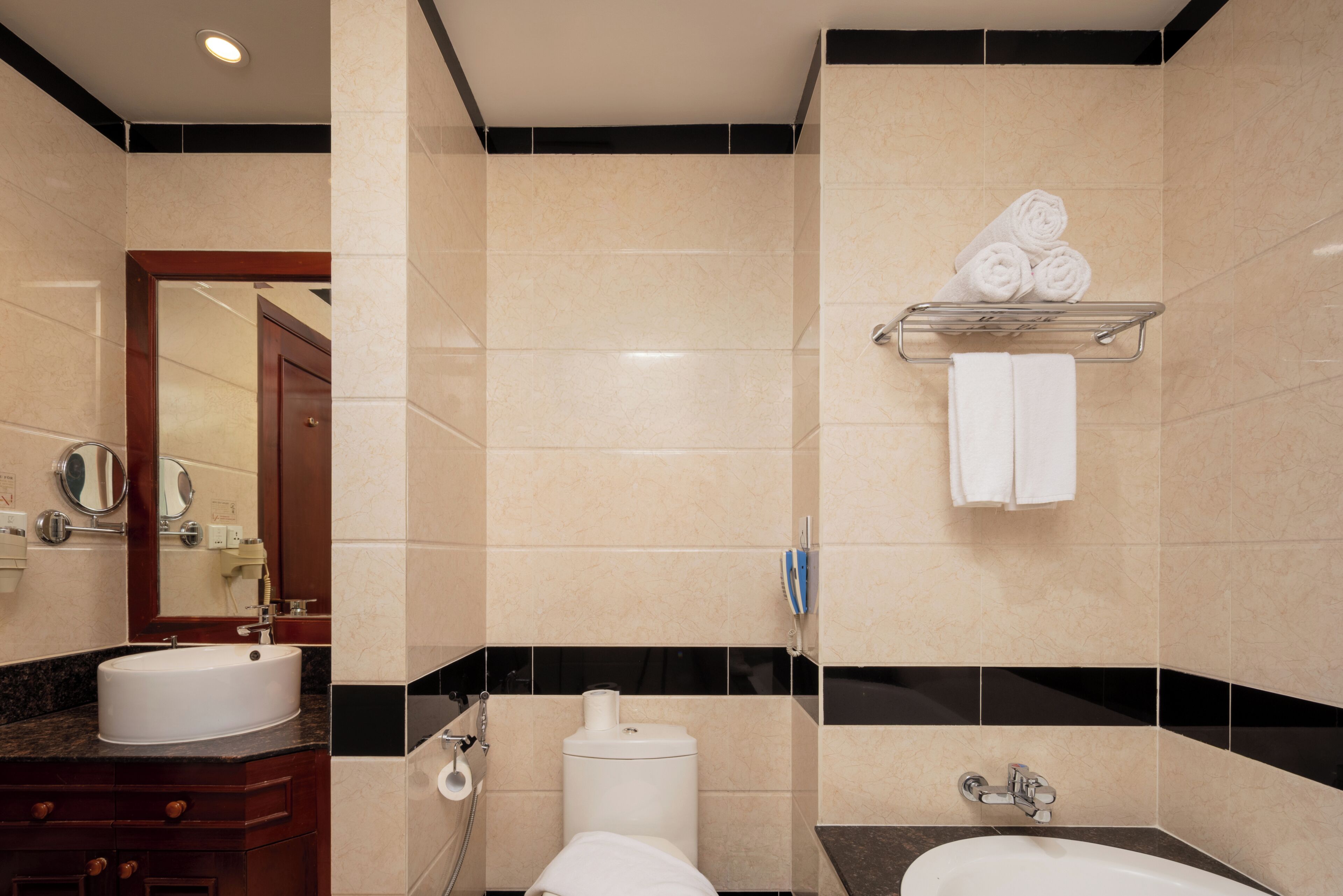 A bathroom with a sink, toilet, and towel rack.