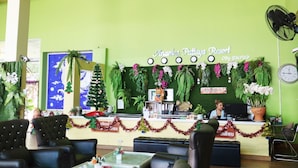 A reception area at Anantara Pataya Resort with a green wall, Christmas decorations, and a clock. - Anantra Resort Pattaya (Pattaya)