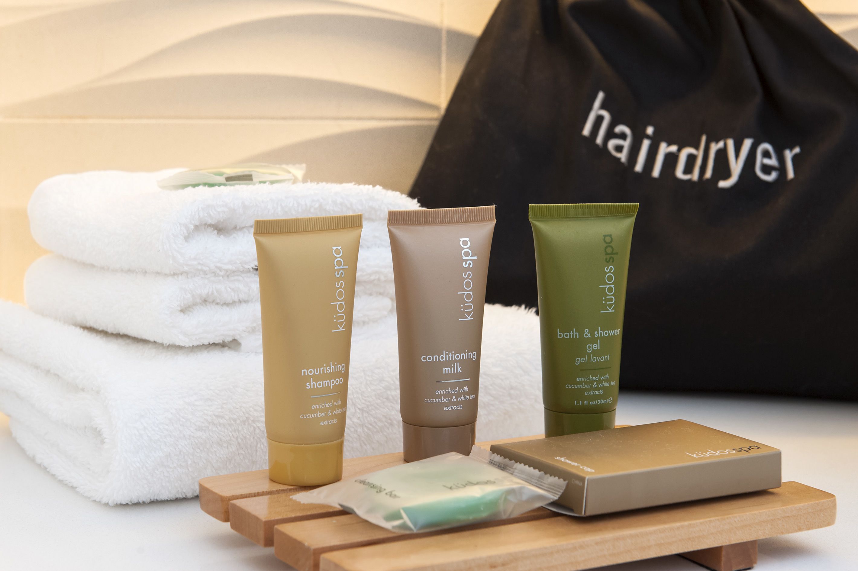 Kiddo spa produkter, herunder nærende shampoo, conditioner og bade- og brusegél, samt en taske til hårtørrer.