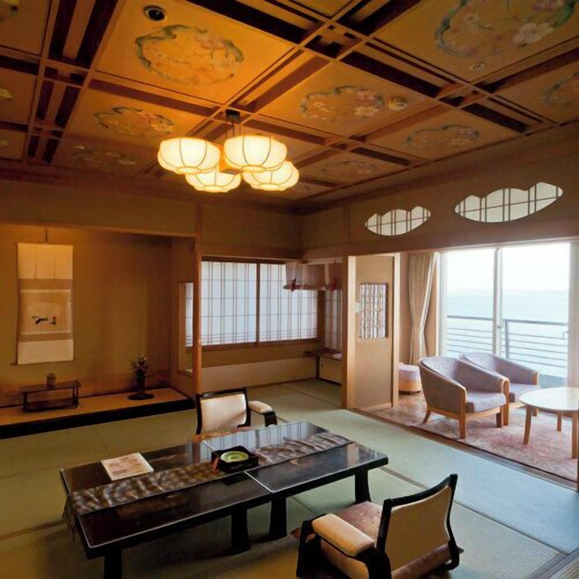 Une pièce de style japonais traditionnel, avec un sol recouvert de tatamis, une table basse avec des coussins et des portes coulissantes.