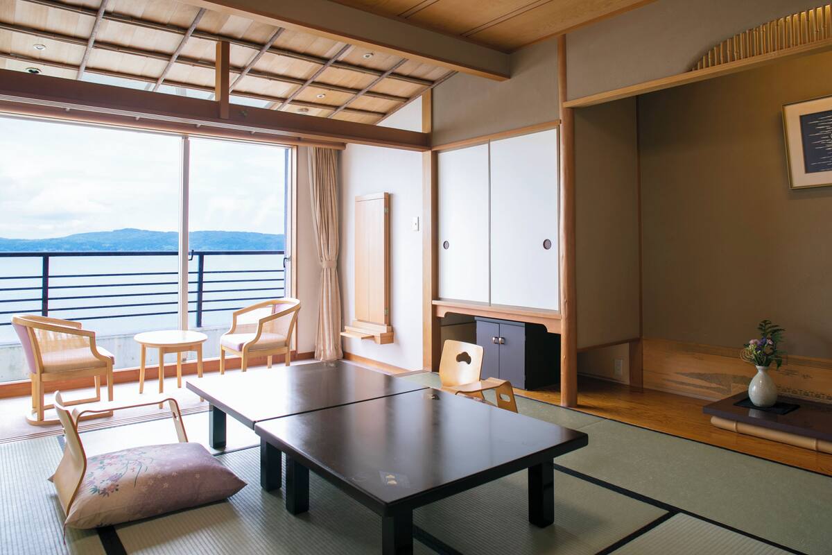 Une pièce de style japonais traditionnel, avec un sol recouvert de tatamis, une table basse et des sièges.
