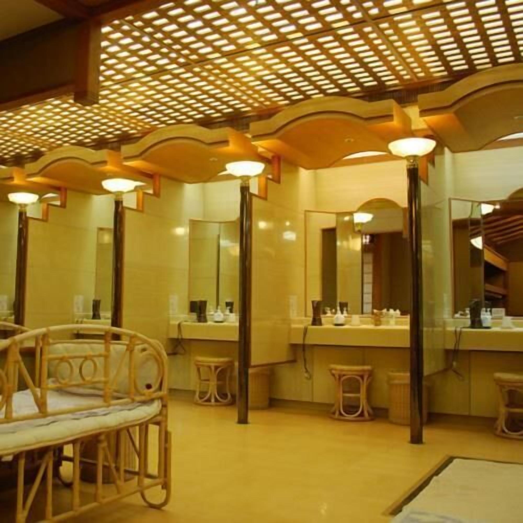Ein Badezimmer mit einer hölzernen Sitzbank, einem Waschbecken mit Spiegel und einer Decke mit Musterdesign.