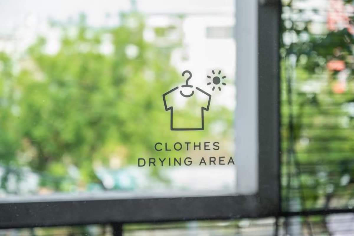 A window with a sign indicating a clothes drying area.