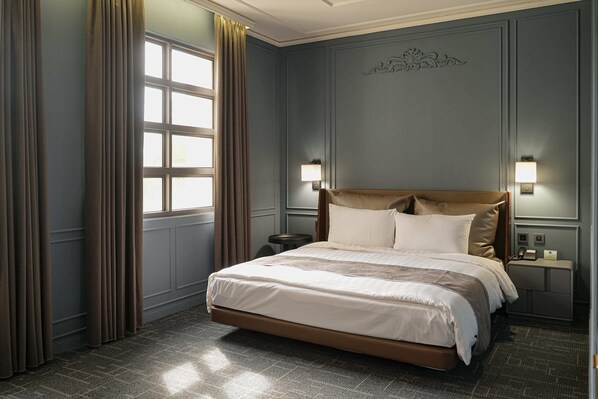 A neatly arranged bedroom with a large bed, two bedside lamps, a nightstand, and a window with curtains. - Golden Tulip - Aesthetics (Zhunan)