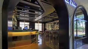 Un área de bar moderna con mostrador, asientos y una pared con texto iluminado.