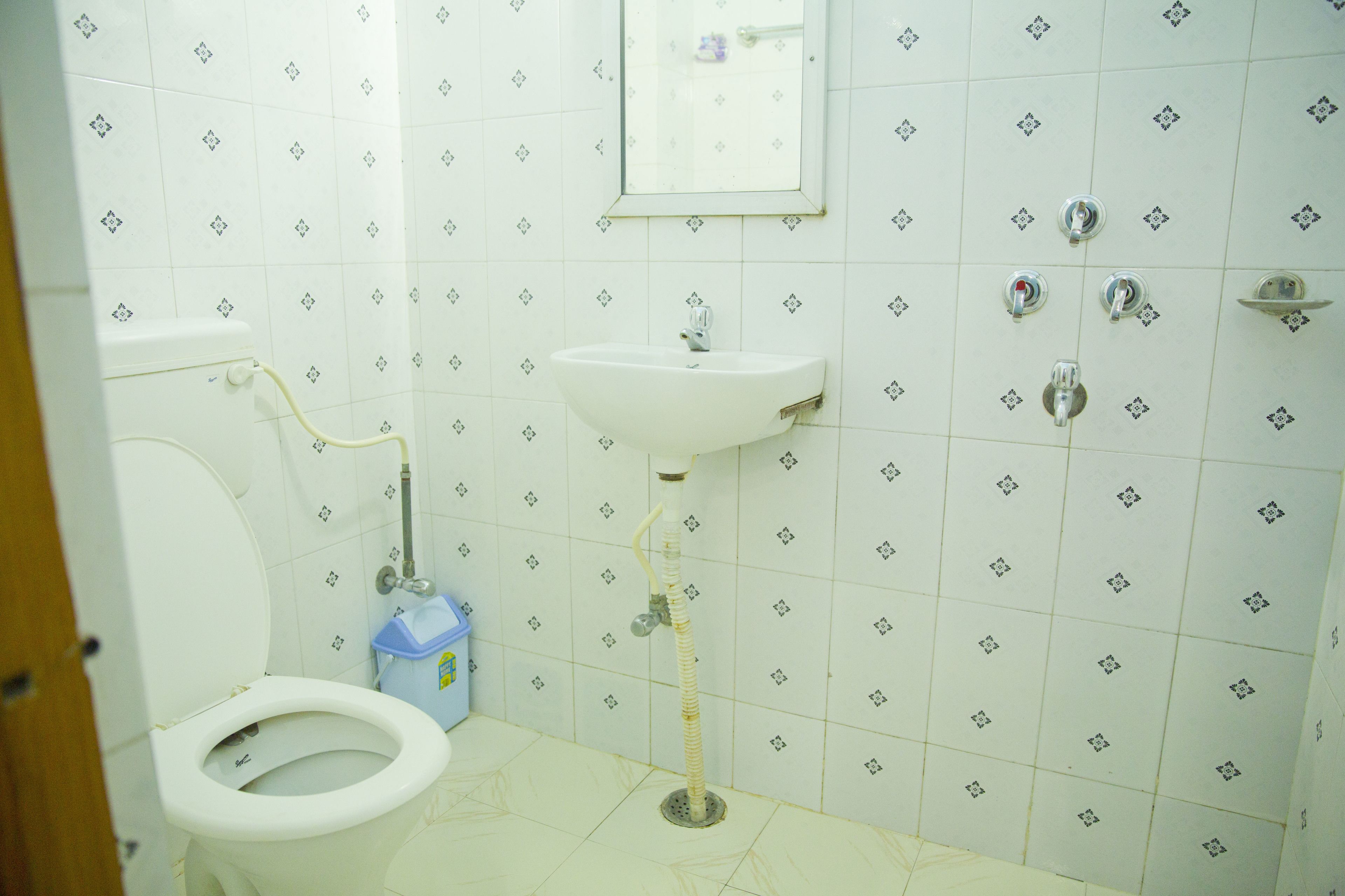 A bathroom with a toilet, sink, and shower.