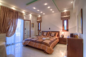 A bedroom with a large bed, bedside tables, a wardrobe, and a window with curtains. - Cretan Residence Mediterranean Luxury Private Villas (Mylopotamos)