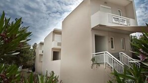 Un bâtiment moderne à deux étages, doté d’un balcon et d’un escalier menant à l’entrée.