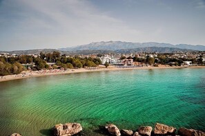 A coastal town with clear turquoise waters, a sandy beach, and a backdrop of mountains. - Marathakis Apartments (Chania)