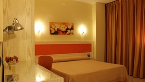 A hotel room with a bed, a desk, a lamp, a painting, and curtains. - Hotel Cristal Eboli (Eboli)