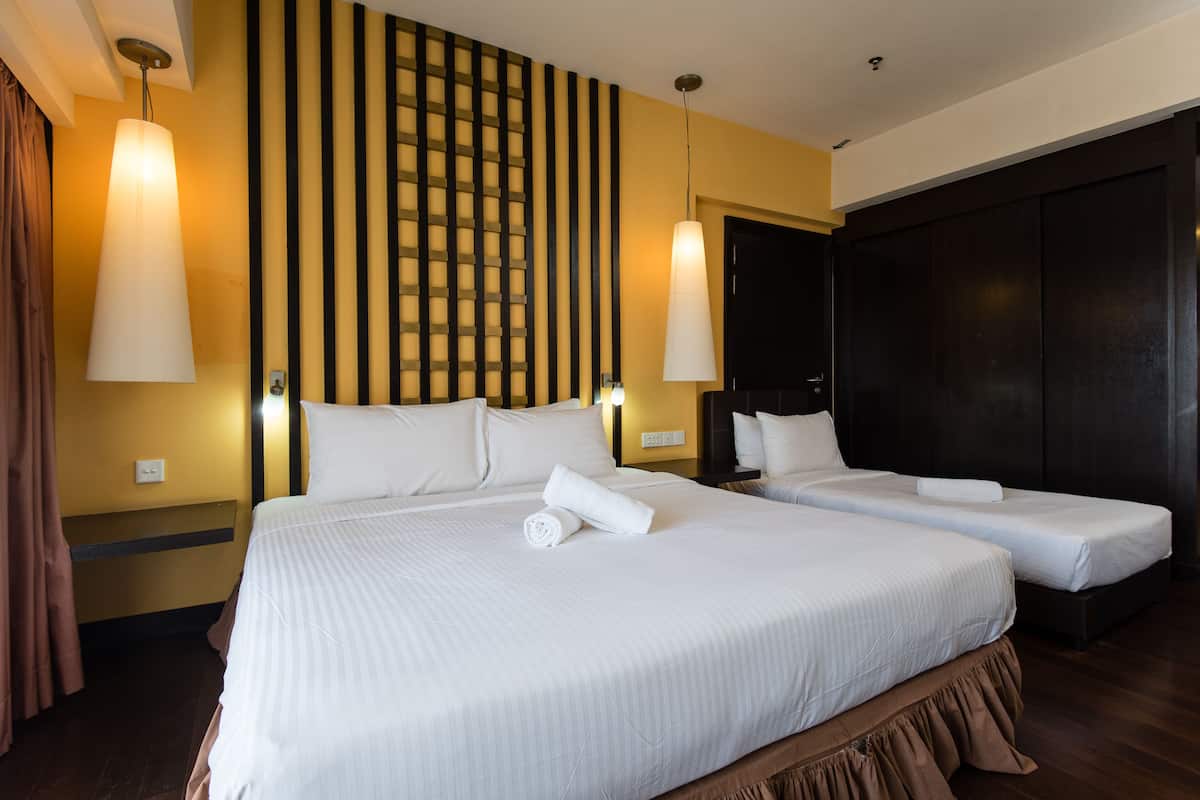 A hotel room with two beds, a large window, and a dark wooden wardrobe.