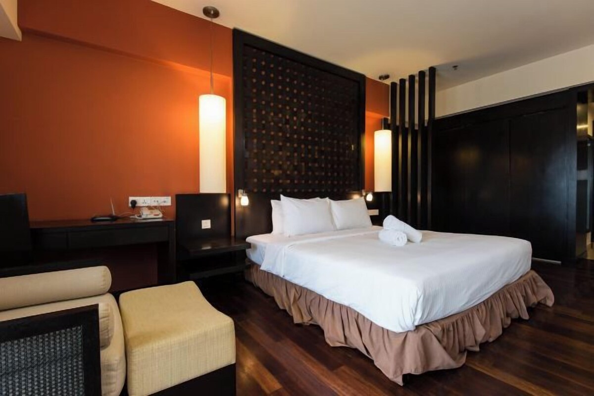 Ein Hotelzimmer mit einem großen Bett, einem Schreibtisch mit Stuhl und einem Kleiderschrank.