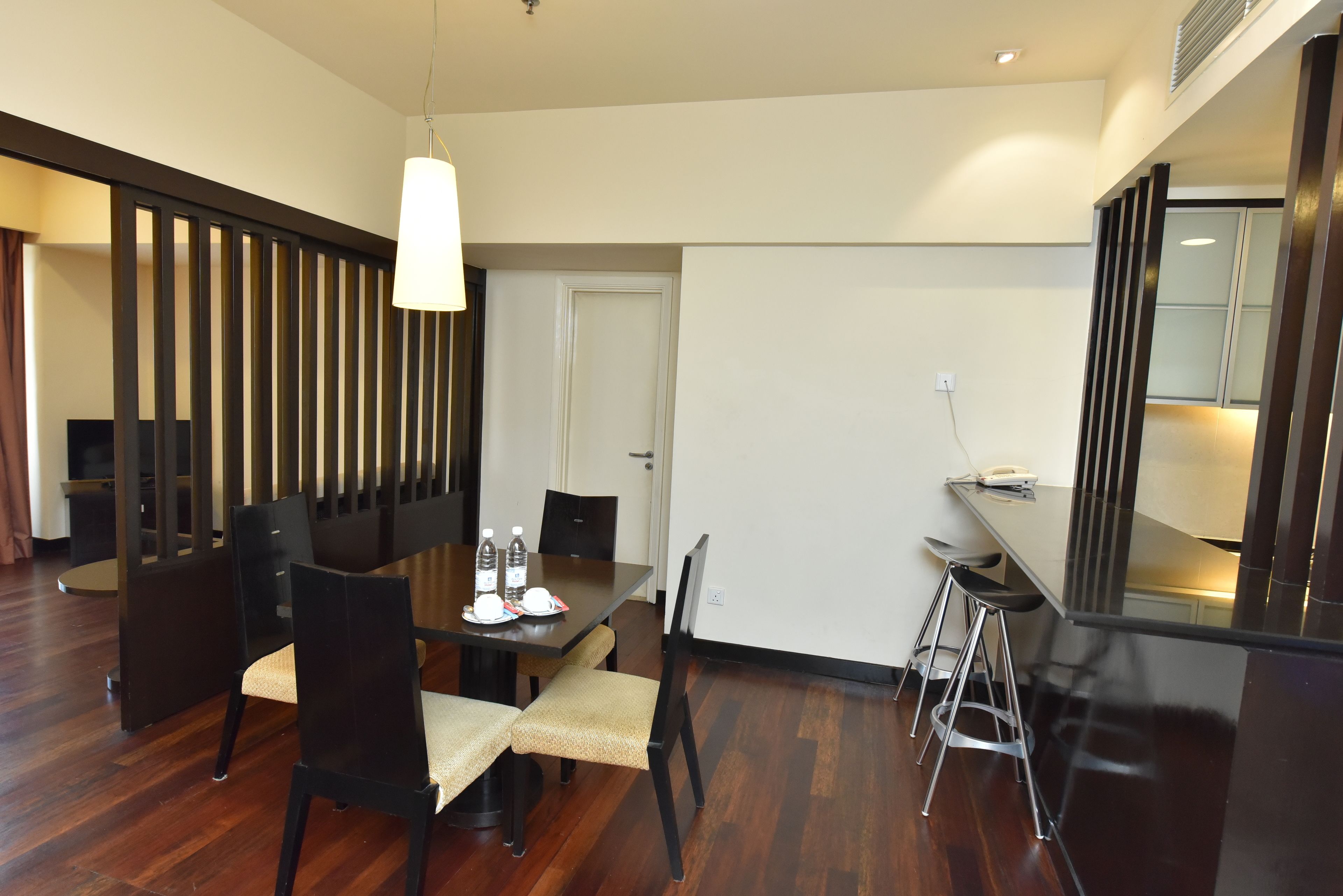 Comedor con mesa de madera, sillas y lámpara colgante.