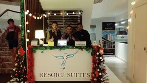 Bancada de recepção em um hotel com uma placa indicando "RESORT SUITES".