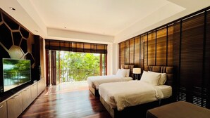 A modern hotel room with two beds, a TV, and a balcony with a view of greenery. - Amatapura Beach Villa 15 (Krabi)