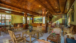 A spacious lobby with wooden furniture, a staircase, and a large painting on the wall. - Side Walk Never Die (Siem Reap)