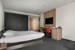 A modern hotel room with a bed, a desk, a TV, and a wardrobe. - Hotel Iselmar (Lemmer)