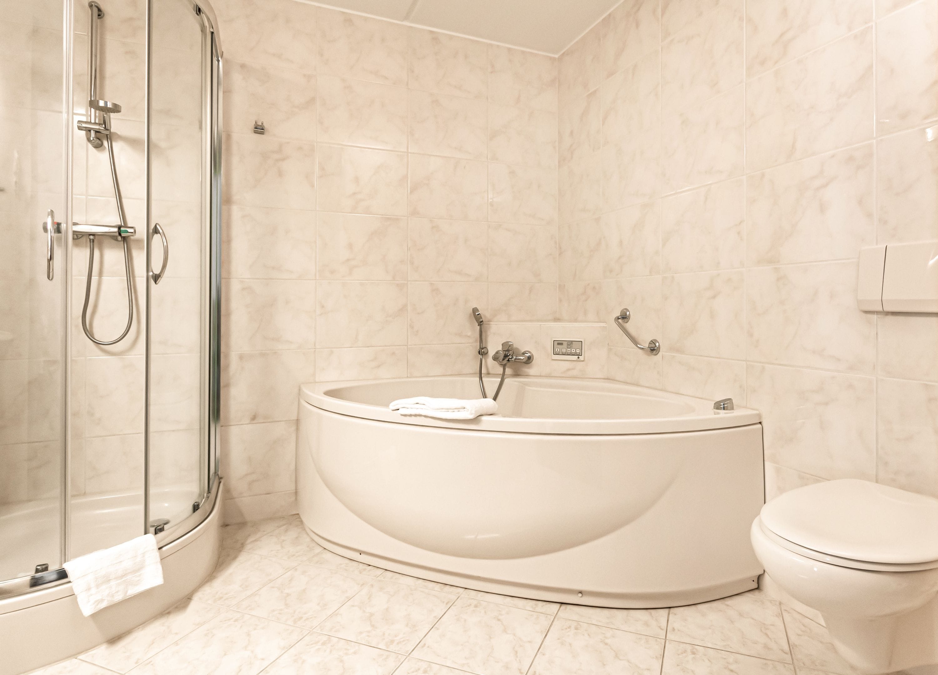 A modern bathroom with a freestanding bathtub, a glass shower enclosure, and a toilet.