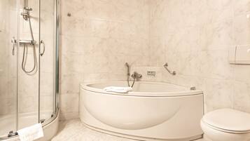 A modern bathroom with a freestanding bathtub, a glass shower enclosure, and a toilet.