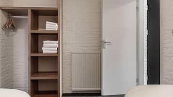 Ein Schlafzimmer mit einem Holzschrank, einem Heizkörper und einer weißen Tür.