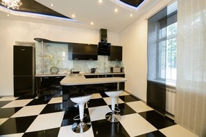 A modern kitchen with a black and white checkered floor, two bar stools, and a large window with blinds. - Kiev Accommodation Hotel Service (Kyiv)