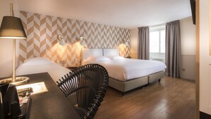 A hotel room with a bed, bedside lamps, a desk with a lamp, a chair, and a window with curtains. - Hôtel Jeanne d'Arc Le Marais (Paris)