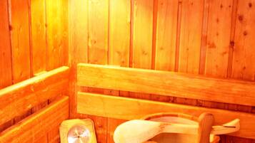 A wooden sauna with benches and a wooden bucket.
