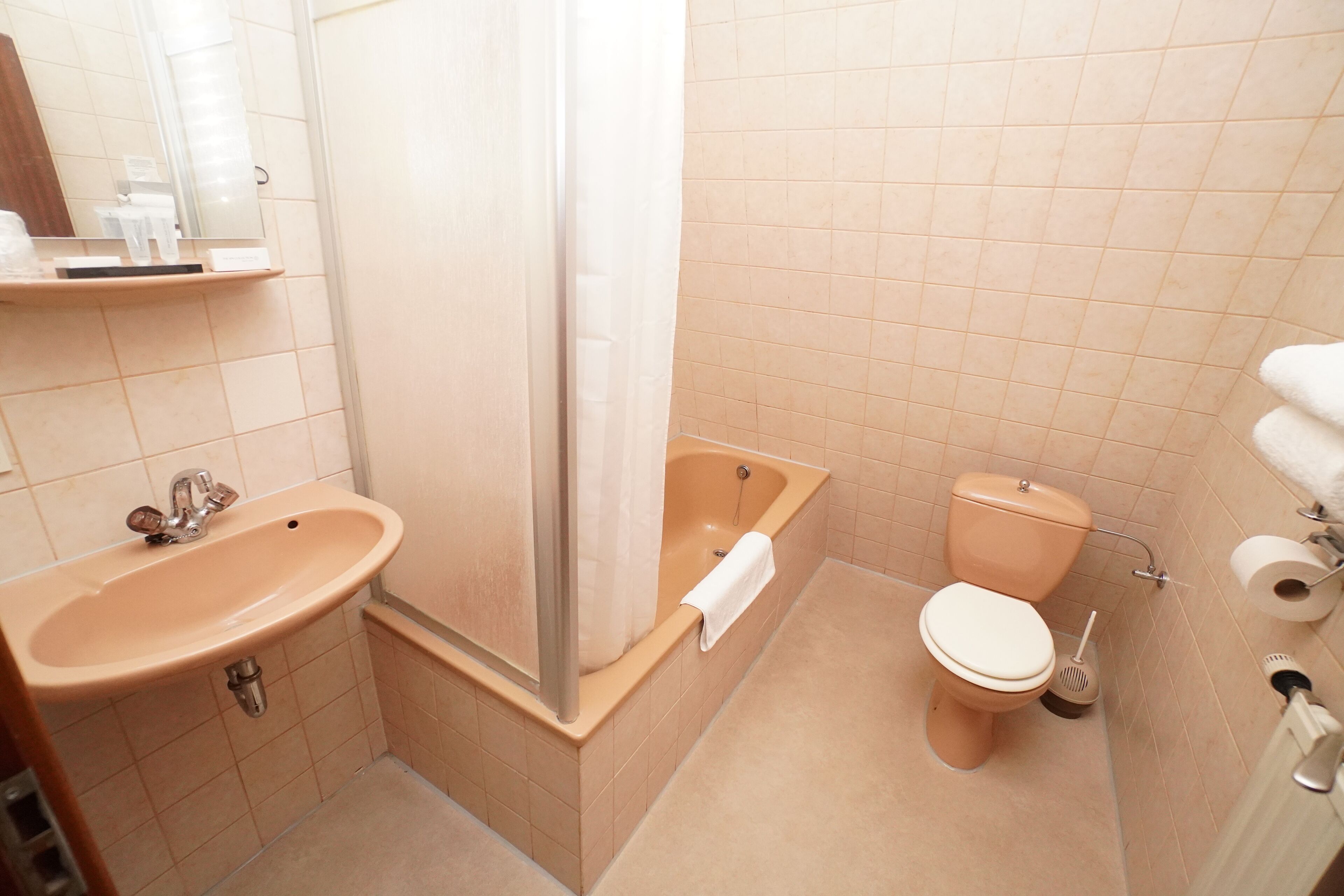 A bathroom with a sink, bathtub, toilet, and shower curtain.