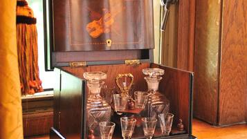 Un mobile in legno con decoro a violino, che contiene diversi decanter e bicchierini di vetro.