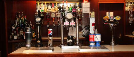 A bar with multiple taps, including Guinness and Pepsi, and a variety of bottles in the background.