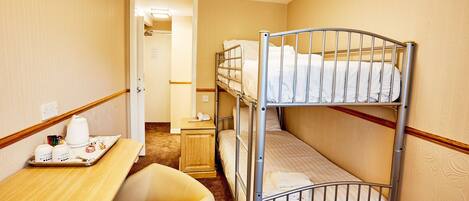 A bunk bed room with a desk, chair, and a tray with breakfast items.