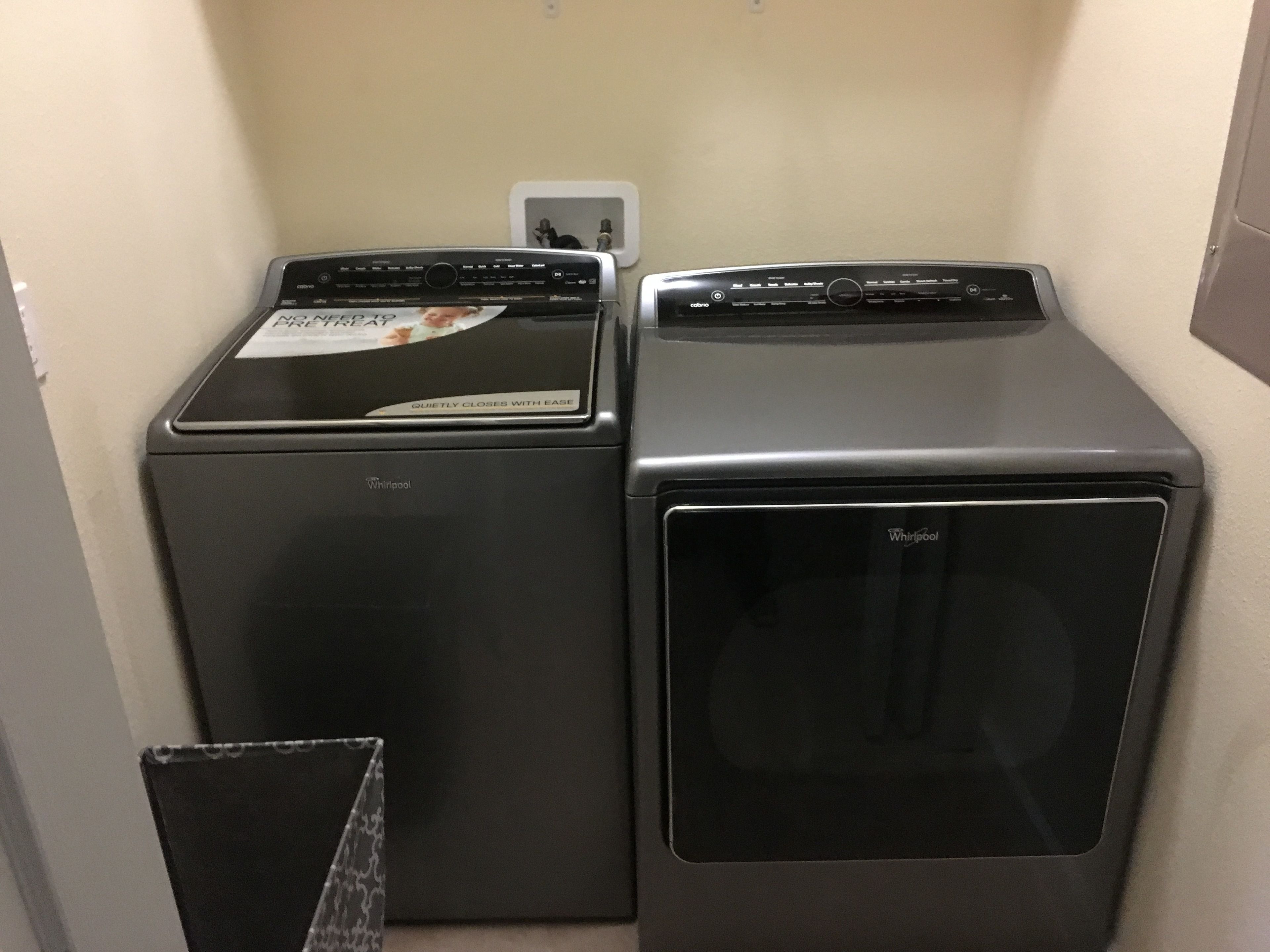 Two stacked Whirlpool appliances, a washer and a dryer, in a compact laundry room.