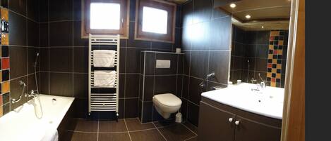 A bathroom with a bathtub, toilet, and sink.