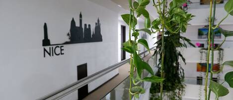 A view of a modern building with a cityscape silhouette and the word "NICE" on the wall.