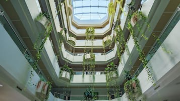 A multi-level atrium with hanging plants and a skylight.