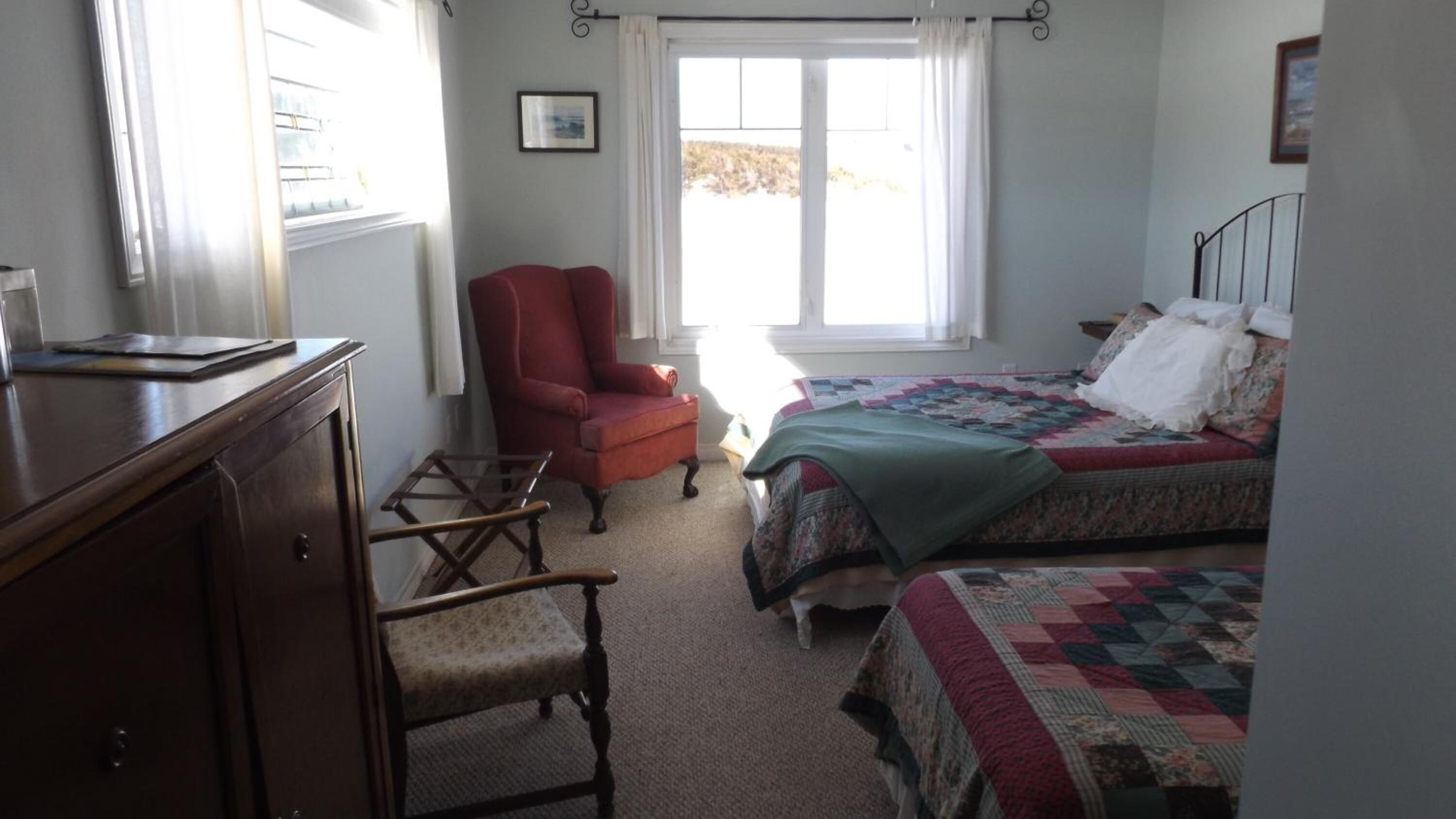 Une chambre à coucher avec un lit, une chaise, un bureau et une fenêtre.