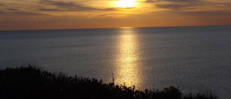 A sunset over a calm sea with a clear horizon.