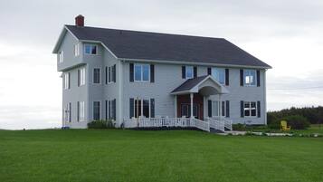 A two-story house with a front porch and a small staircase leading to the entrance.