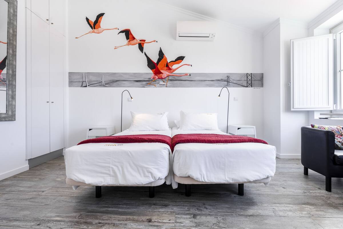 Una habitación de hotel moderna con dos camas, un espejo grande y obras de arte en la pared.