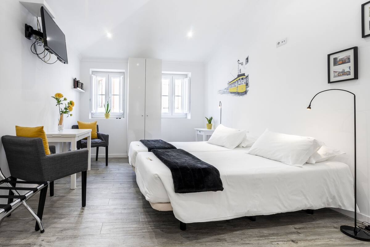 Un dormitorio moderno con una cama grande, un escritorio y una silla.