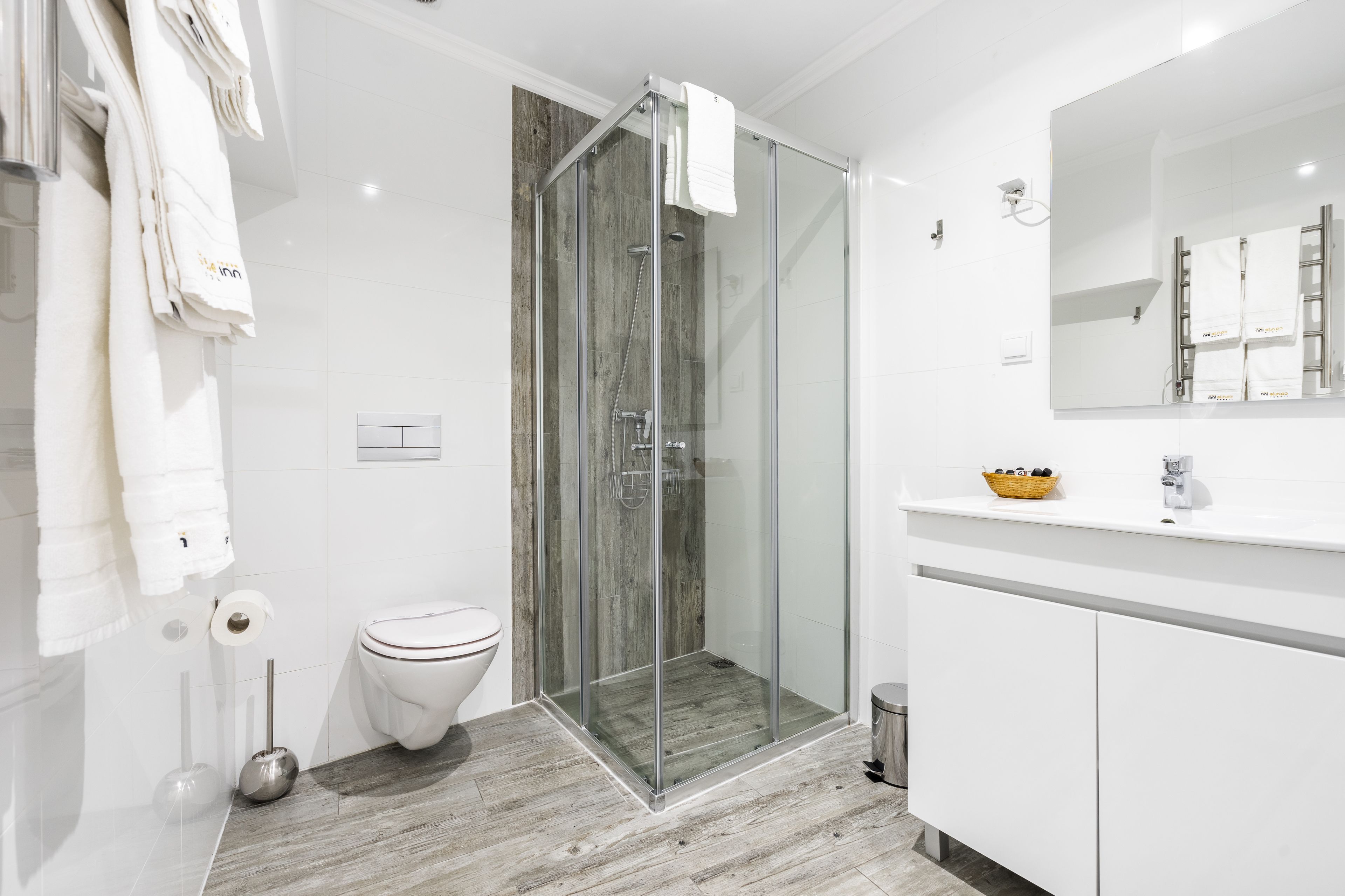 Une salle de bain moderne avec une douche à parois de verre, des toilettes et un meuble-lavabo avec un miroir.