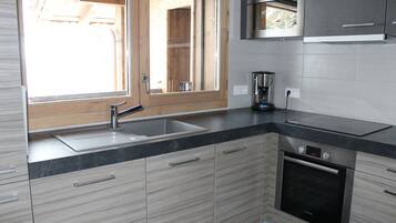 Una cucina moderna con forno a incasso, lavello e finestra.