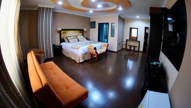 A hotel room with a bed, a sofa, a TV, and a desk. - Hotel Boutique Mary Carmen (Ambato)