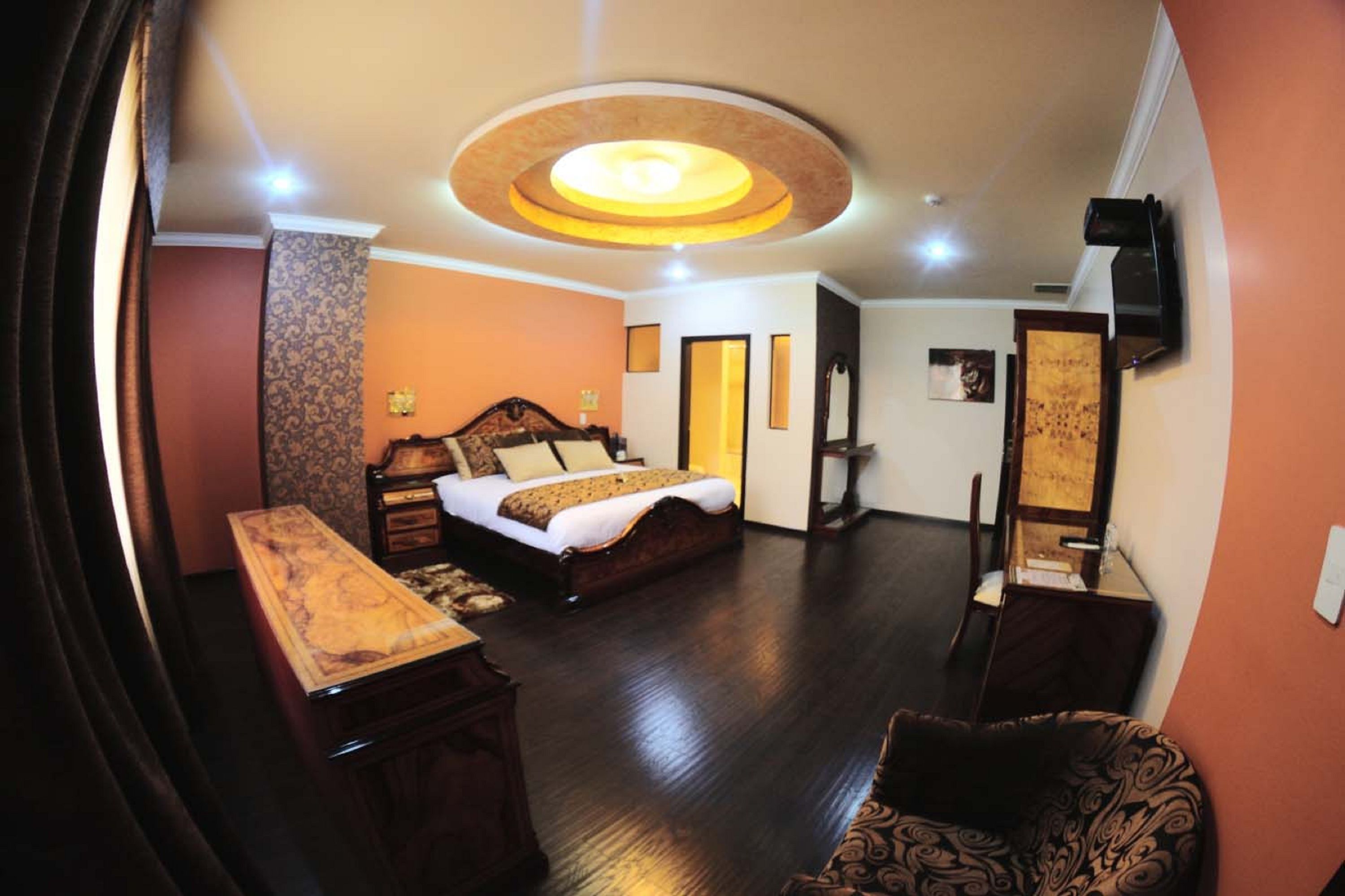 Une chambre d’hôtel avec un lit, un bureau, une chaise et un téléviseur.