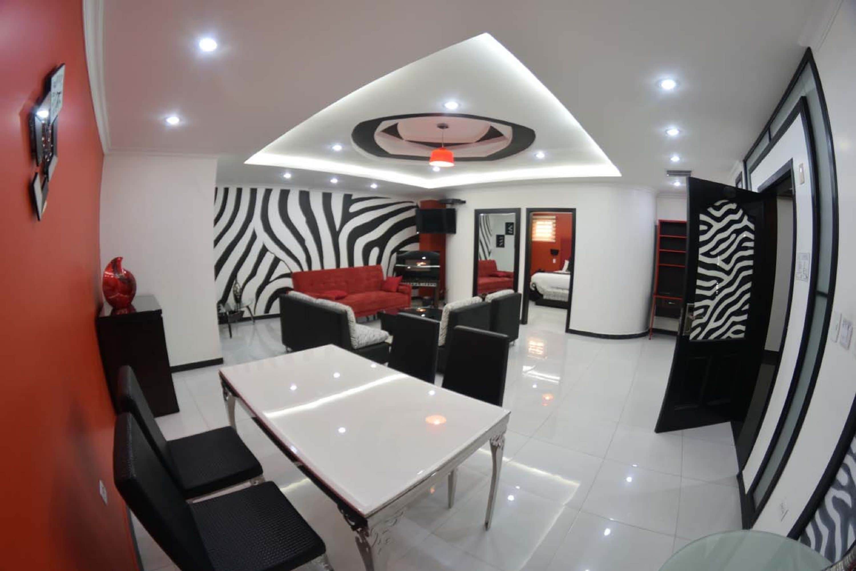 Un interior moderno con zona de comedor, asientos y pared con estampado de cebra.