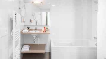 Un baño moderno con bañera, lavamanos y espejo.