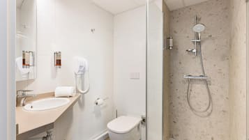 Une salle de bain moderne avec un lavabo, des toilettes et une douche à parois de verre.