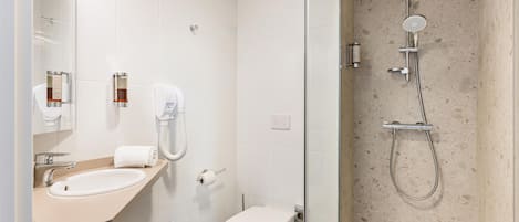 A modern bathroom with a sink, toilet, and glass-enclosed shower.